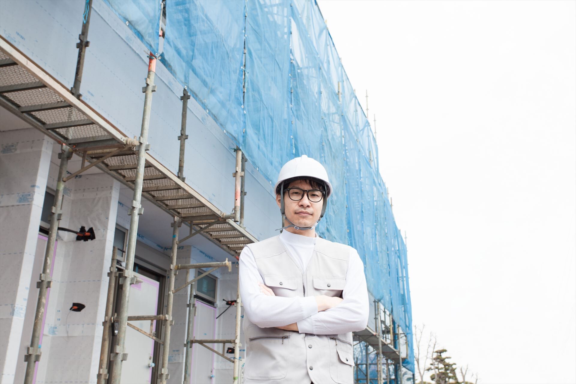 足場の前でポーズを決めるスタッフ